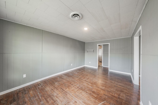 spare room featuring wood walls and hardwood / wood-style flooring