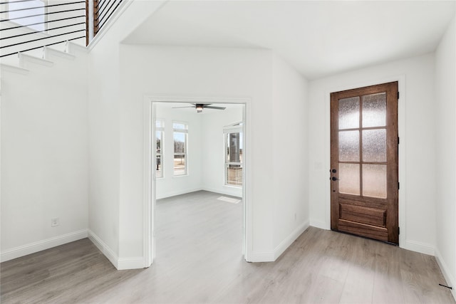 entrance foyer with stairs, baseboards, and light wood-type flooring