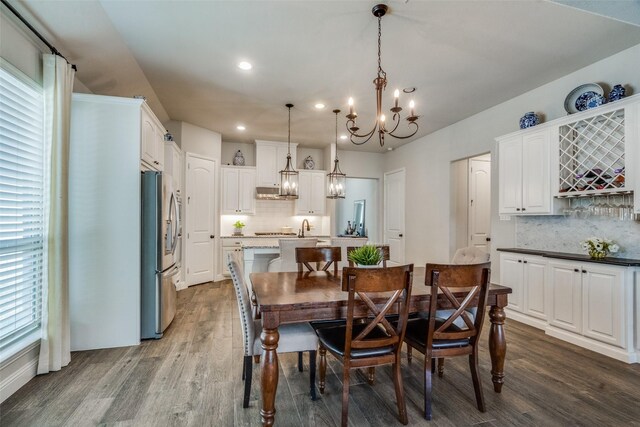 dining room with dark hardwood / wood-style flooring and a notable chandelier