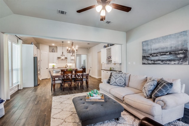 living room with ceiling fan with notable chandelier, dark hardwood / wood-style flooring, and a wealth of natural light