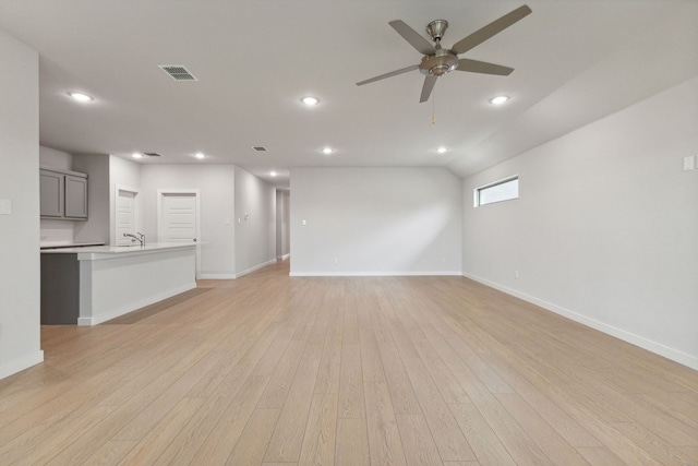 unfurnished living room featuring ceiling fan, sink, and light hardwood / wood-style floors