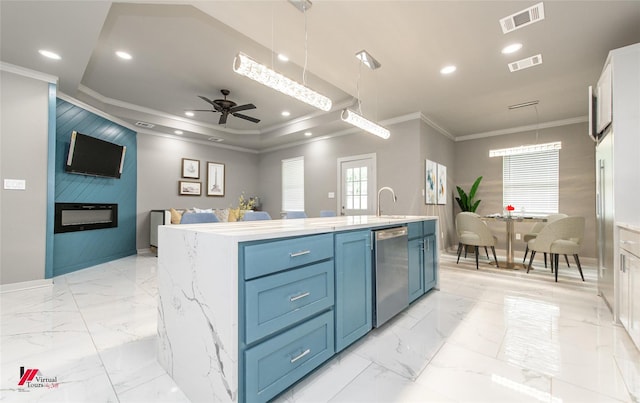 kitchen featuring white cabinetry, ceiling fan, blue cabinets, an island with sink, and pendant lighting