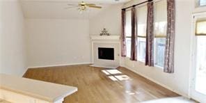 unfurnished living room featuring wood-type flooring and ceiling fan