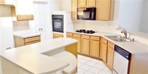 kitchen with black appliances, light tile patterned floors, and sink