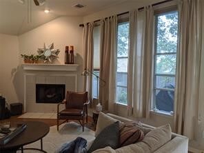 living room featuring ceiling fan, lofted ceiling, and a wealth of natural light