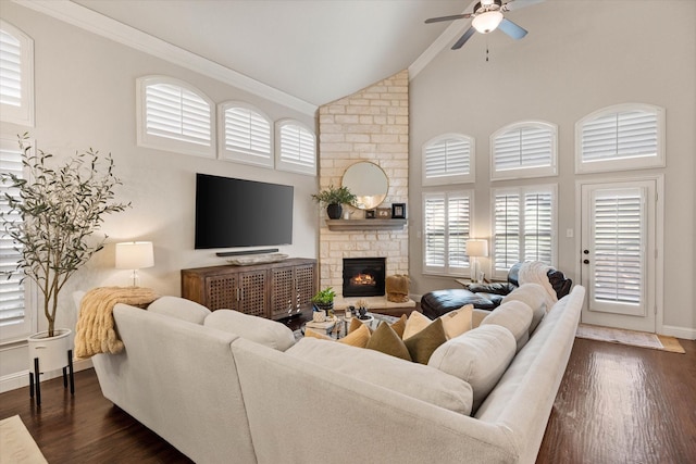 living room featuring high vaulted ceiling, dark hardwood / wood-style flooring, ceiling fan, and a stone fireplace