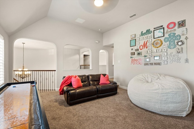 carpeted living room with vaulted ceiling and ceiling fan with notable chandelier