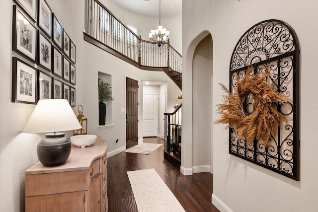 entrance foyer featuring a high ceiling, dark wood-type flooring, and a chandelier