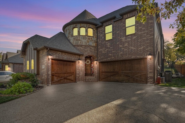 view of front of property with a garage and central AC