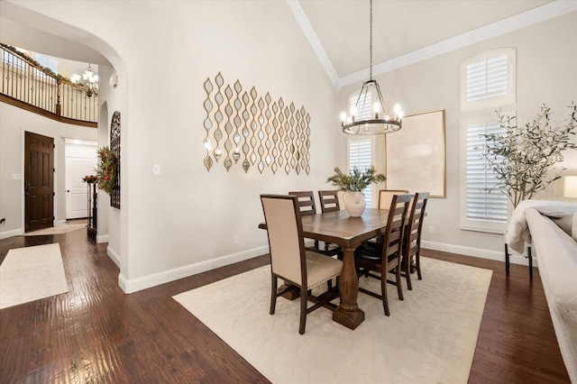 dining space with high vaulted ceiling, crown molding, a chandelier, and dark hardwood / wood-style floors