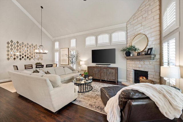 living room featuring high vaulted ceiling, ornamental molding, hardwood / wood-style flooring, and a stone fireplace