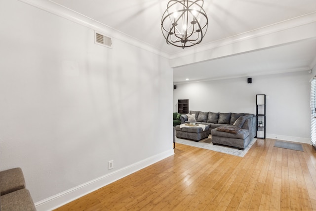 living room featuring a chandelier, ornamental molding, and hardwood / wood-style flooring