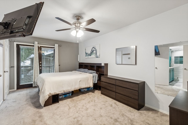 bedroom featuring light carpet, ensuite bath, and ceiling fan