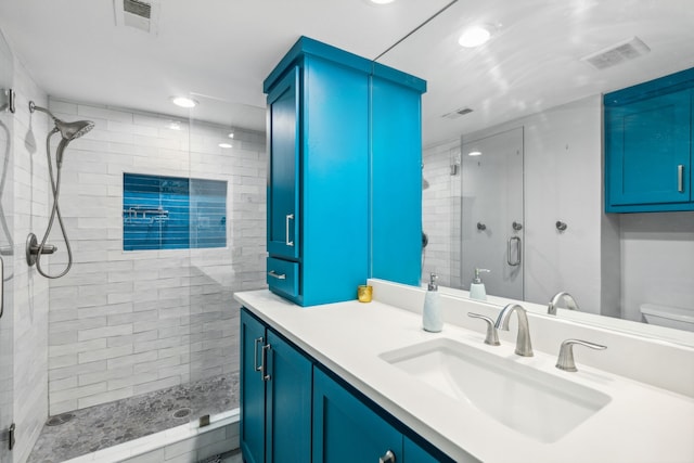 bathroom featuring vanity, toilet, and a shower with door