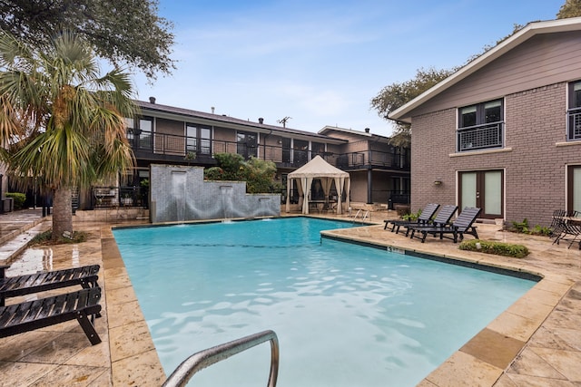 view of swimming pool featuring french doors, a patio, and a gazebo