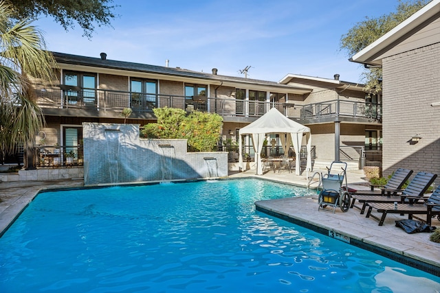 view of swimming pool featuring a gazebo, pool water feature, and a patio