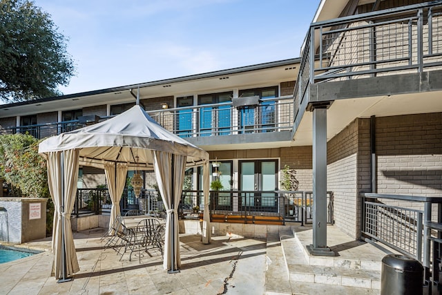 exterior space with a gazebo, a balcony, and french doors