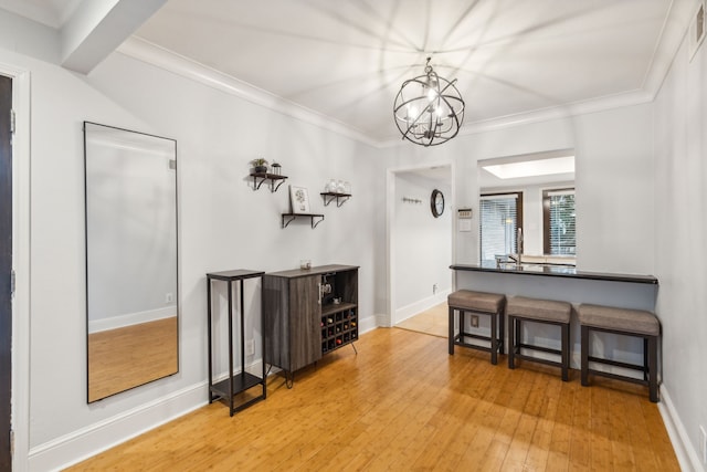 interior space with a chandelier, wood-type flooring, and crown molding