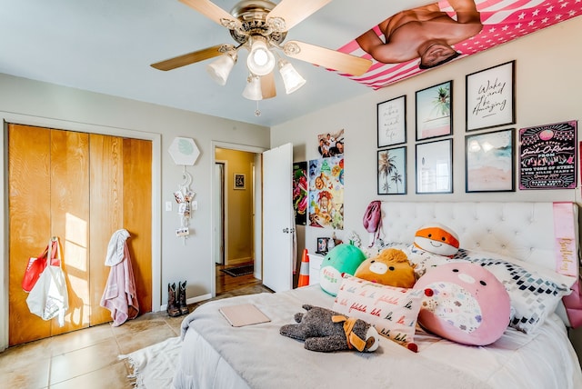 bedroom featuring ceiling fan, light tile patterned floors, and a closet