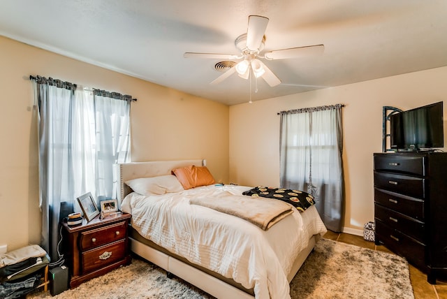 bedroom with ceiling fan and light tile patterned flooring