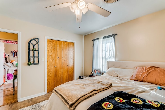 tiled bedroom featuring ceiling fan and a closet