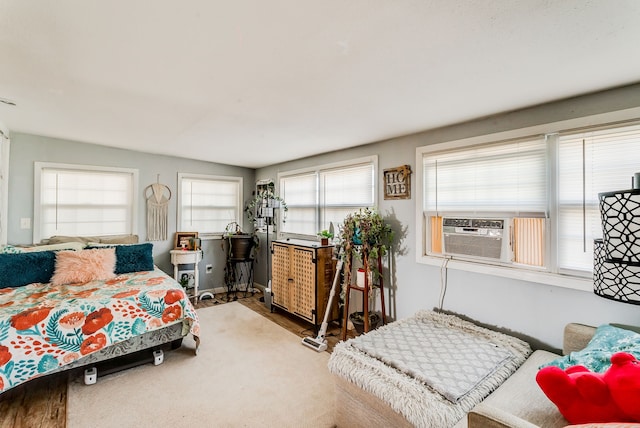 bedroom with multiple windows, hardwood / wood-style floors, and cooling unit