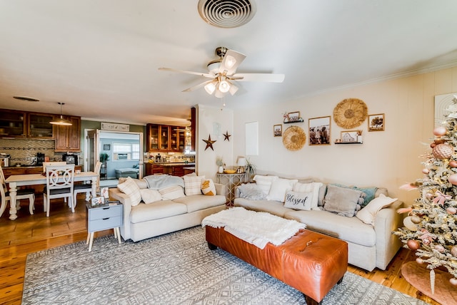 living room featuring ceiling fan, crown molding, and hardwood / wood-style flooring