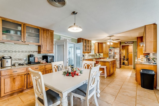 dining space with ceiling fan, crown molding, and light tile patterned floors