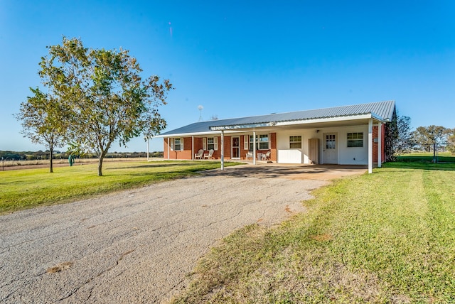 single story home featuring covered porch, a front yard, and a carport