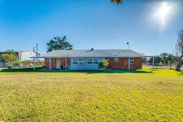 rear view of property featuring a lawn