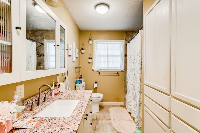 bathroom featuring tile patterned flooring, vanity, and toilet