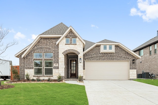 view of front of house with a garage, central AC, and a front lawn