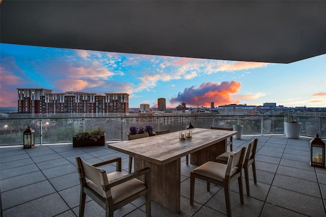 patio terrace at dusk featuring a balcony