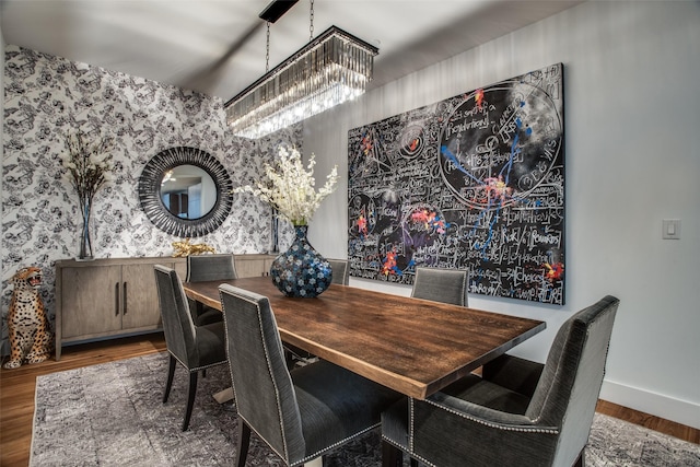 dining space with wood-type flooring and an inviting chandelier