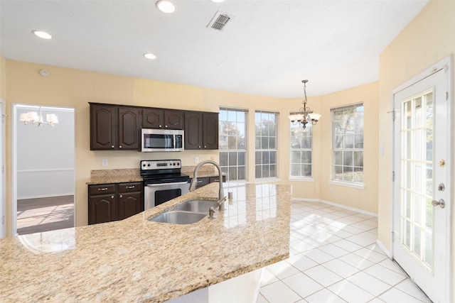 kitchen with dark brown cabinetry, sink, hanging light fixtures, appliances with stainless steel finishes, and a notable chandelier