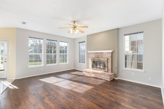 unfurnished living room featuring dark hardwood / wood-style flooring, a fireplace, and ceiling fan