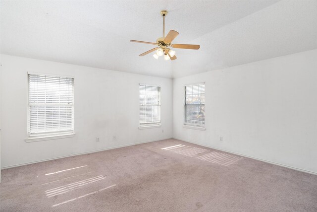 unfurnished room with vaulted ceiling, light colored carpet, and ceiling fan