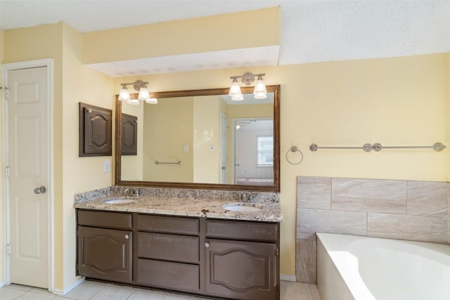 bathroom featuring tile patterned flooring, vanity, and a bath