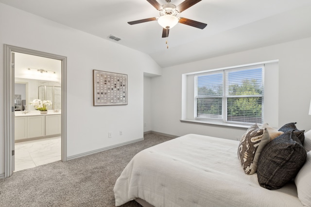 bedroom featuring ensuite bath, ceiling fan, light carpet, and lofted ceiling