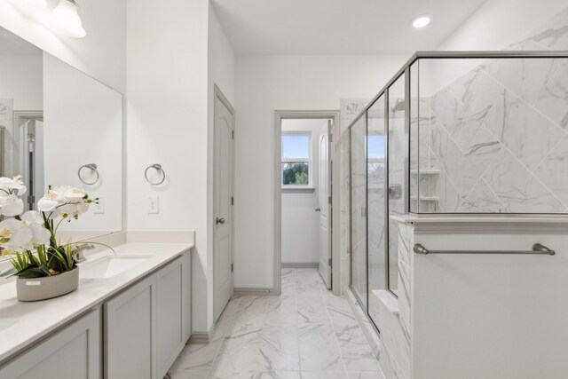 bathroom with a shower with door and vanity