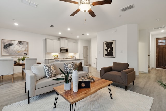 living room featuring ceiling fan and light hardwood / wood-style floors