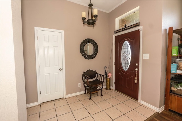 tiled foyer with a chandelier and ornamental molding