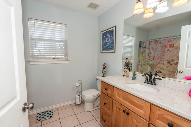 bathroom featuring tile patterned floors, a wealth of natural light, vanity, and toilet