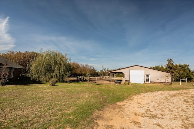 view of yard with a garage and an outbuilding