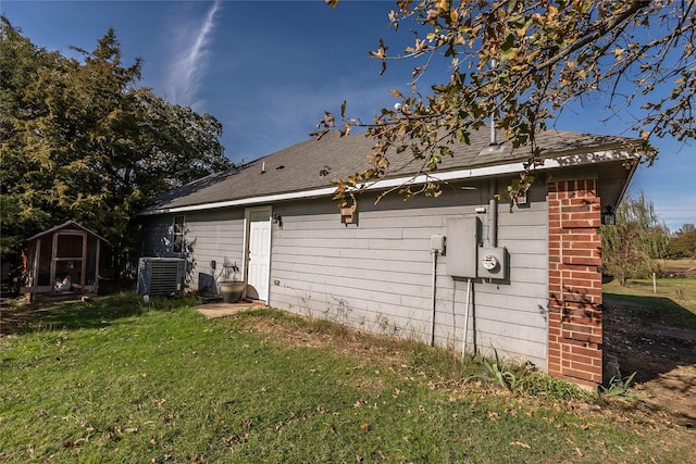 view of home's exterior with a yard, cooling unit, and a shed