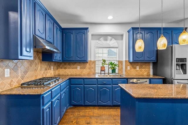 kitchen with dark wood-type flooring, blue cabinets, hanging light fixtures, dark stone countertops, and stainless steel appliances