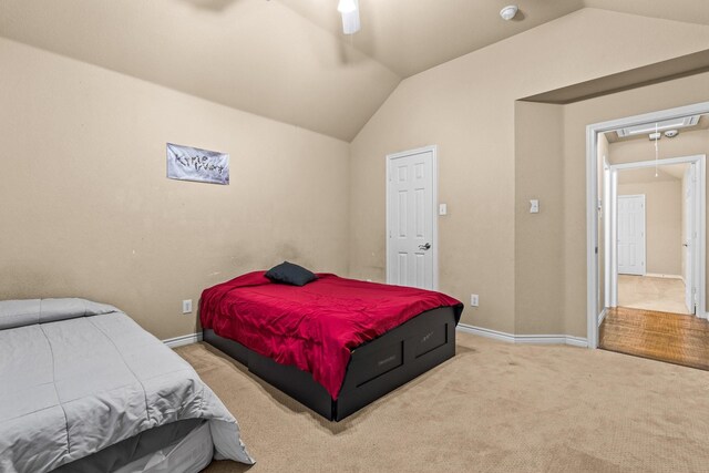 carpeted bedroom with ceiling fan and vaulted ceiling