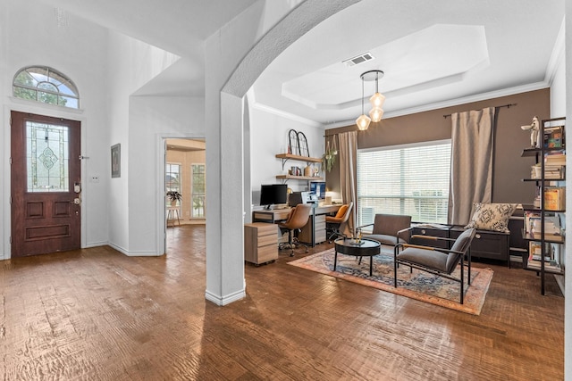 entrance foyer with crown molding, dark hardwood / wood-style floors, and a raised ceiling