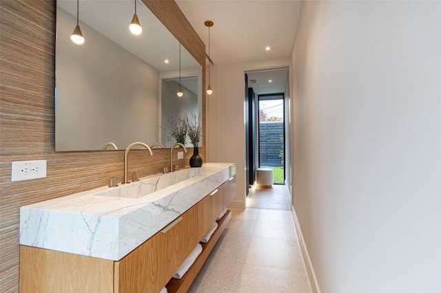 interior space featuring light stone countertops, sink, and decorative light fixtures