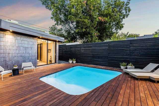 pool at dusk with a deck